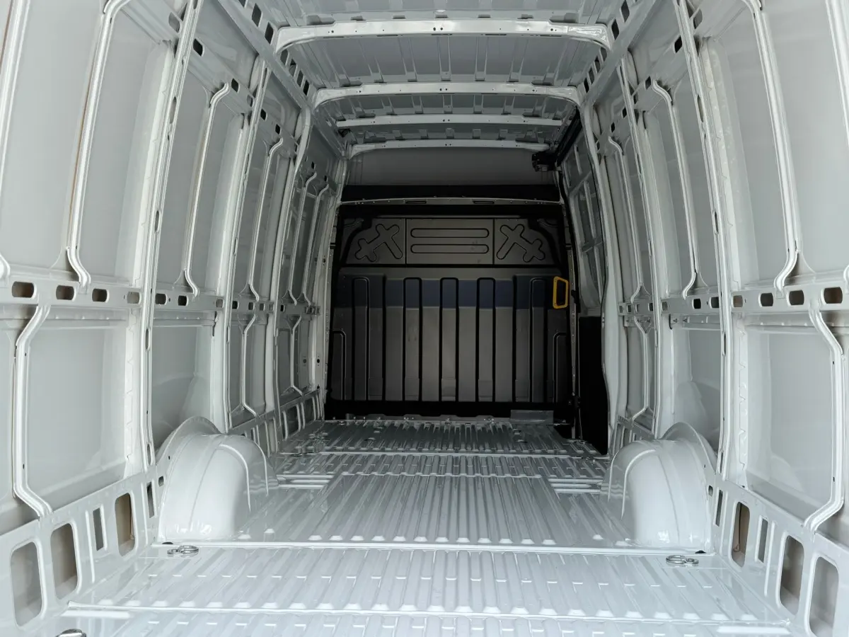 Vue intérieure arrière du fourgon blanc Iveco Daily 35S18 2026, montrant l’espace de chargement vide et les parois métalliques.