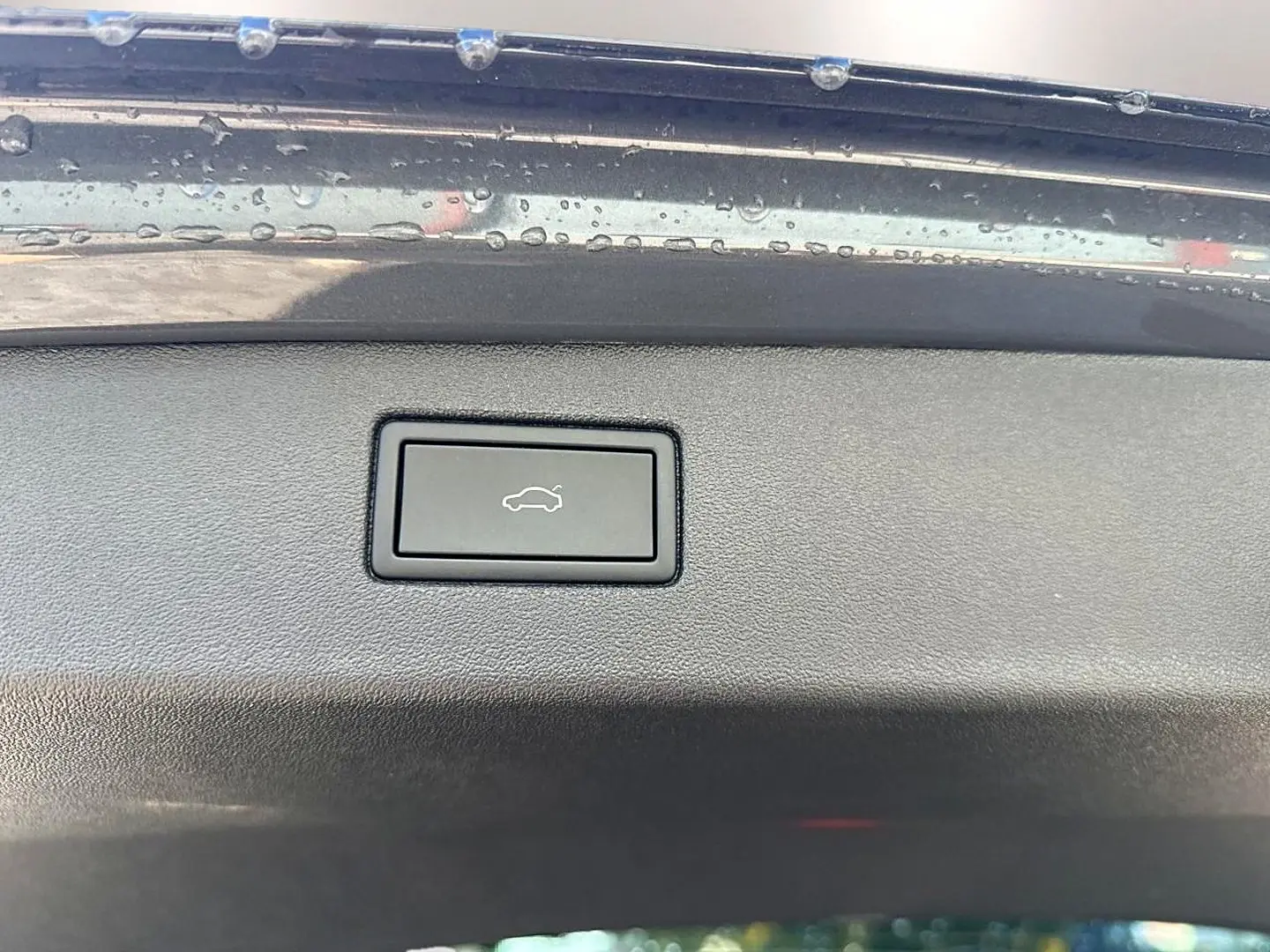 Bouton d'ouverture électrique du coffre sur la partie intérieure du hayon gris dauphin du Volkswagen Tiguan 2024.