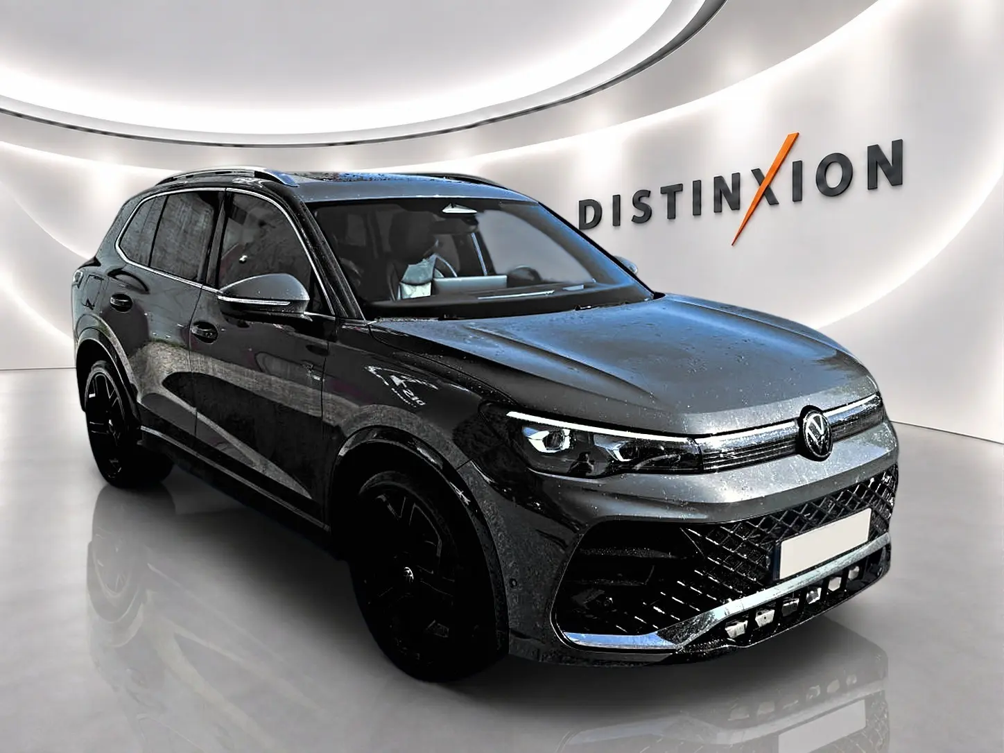 Volkswagen Tiguan 2.0 TDI 150 R-Line gris dauphin en 3/4 avant droit dans un showroom lumineux.