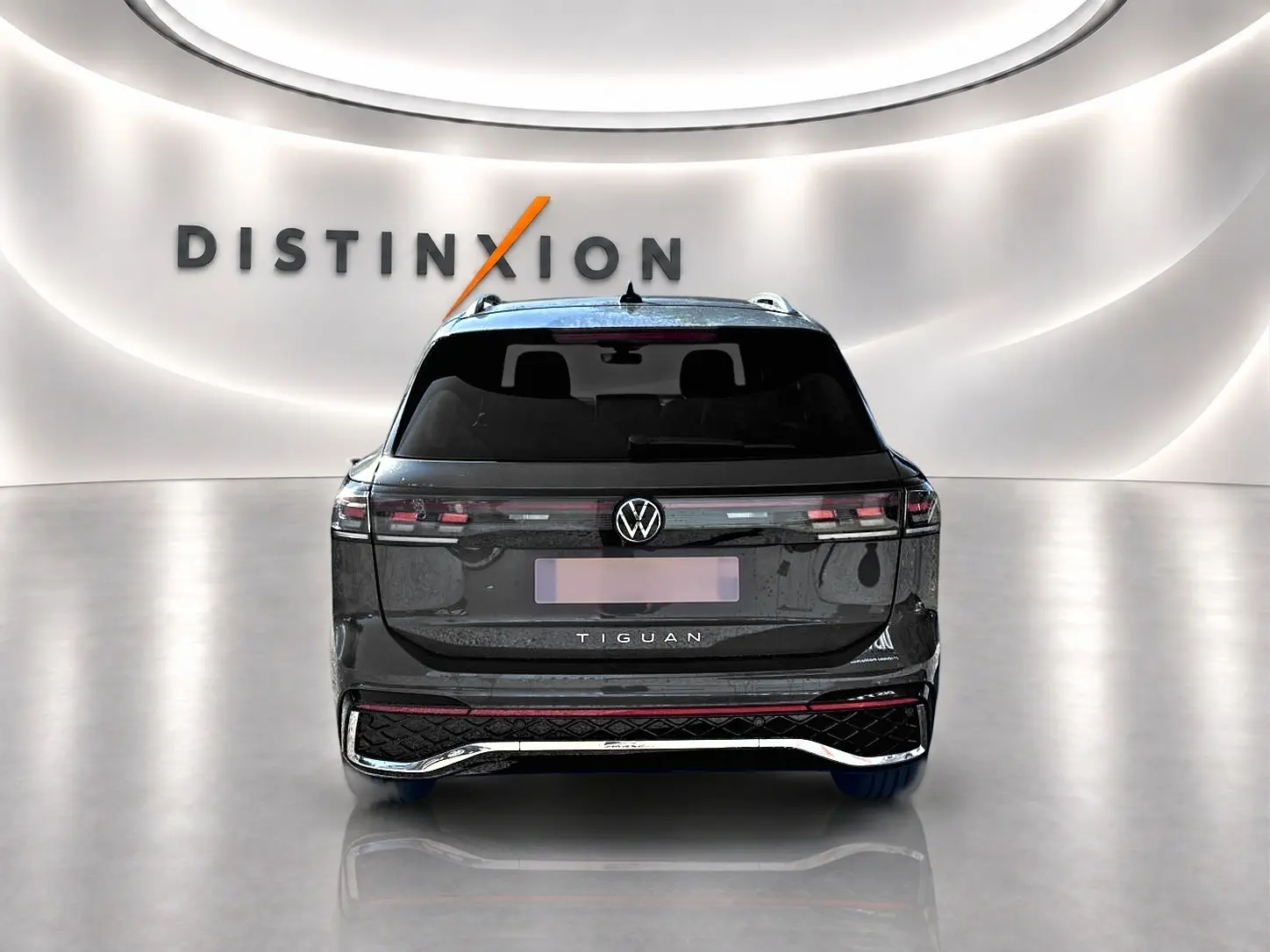 Vue arrière d'un Volkswagen Tiguan gris dauphin 2024 avec feux LED et logo VW bien visibles.