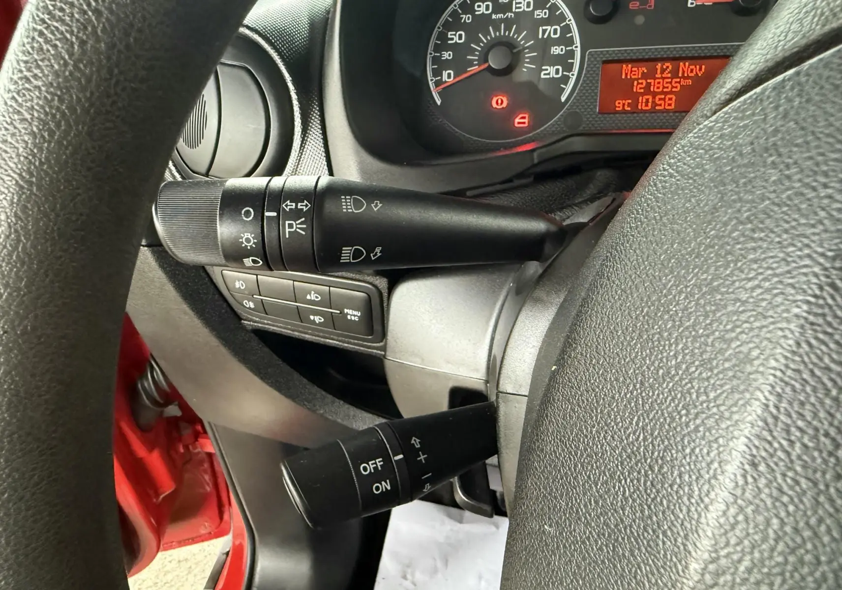 Vue rapprochée du tableau de bord et des commandes au volant d’un Peugeot Bipper Tepee rouge, 2013.