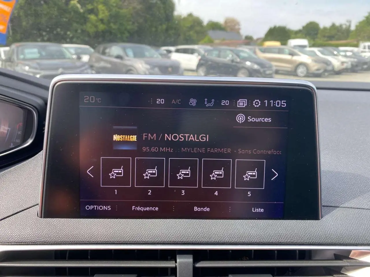 Affichage central tactile du Peugeot 3008 gris platinium, vue intérieure frontale sur l'écran multimédia FM Nostalgie à 11h05