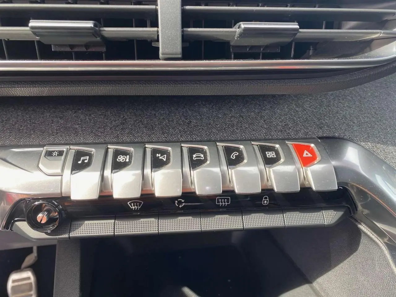 Gros plan sur la rangée de boutons argentés et rouge du tableau de bord du Peugeot 3008 gris platinium, version GT Line 2018.