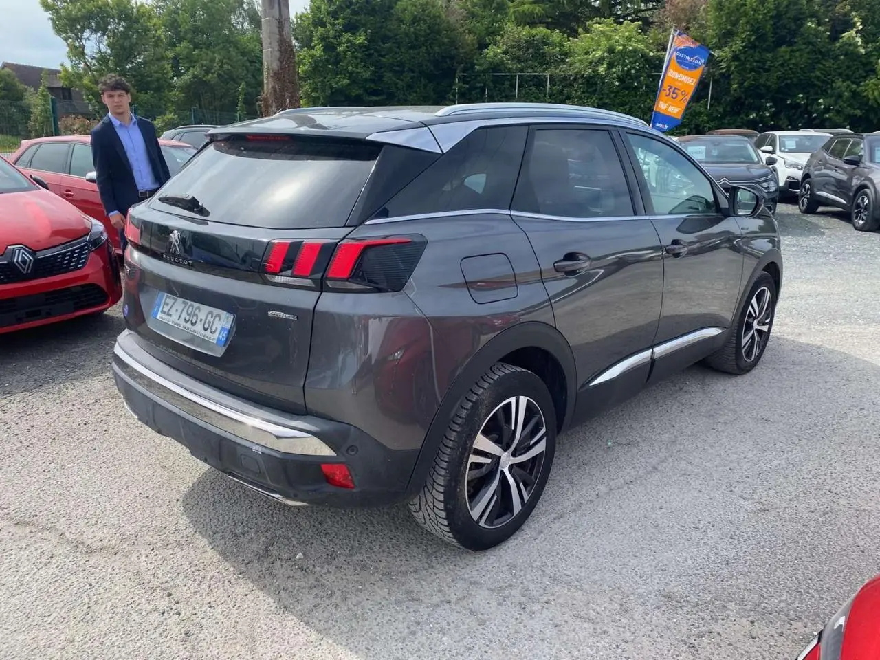 Peugeot 3008 gris platinium vue 3/4 arrière droit, avec barres de toit aluminium et feux LED distinctifs.