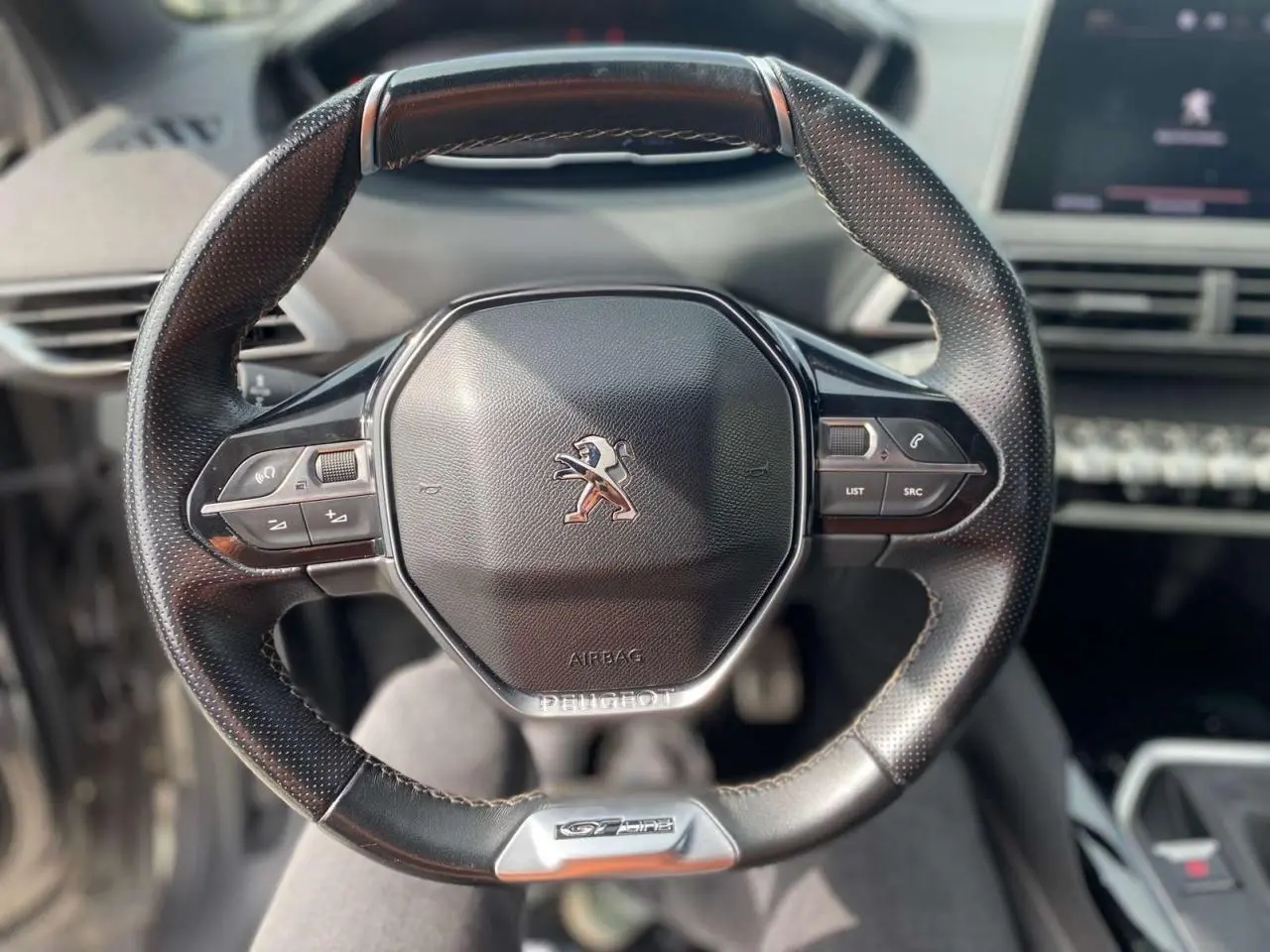 Vue rapprochée du volant cuir perforé du Peugeot 3008 GT Line 2018 avec commandes intégrées et logo lion central.