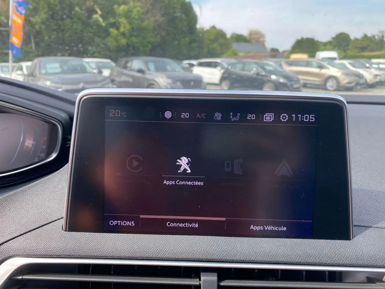 Écran tactile central du Peugeot 3008 GT Line 2018 affichant les options de connectivité, avec vue extérieure floue.