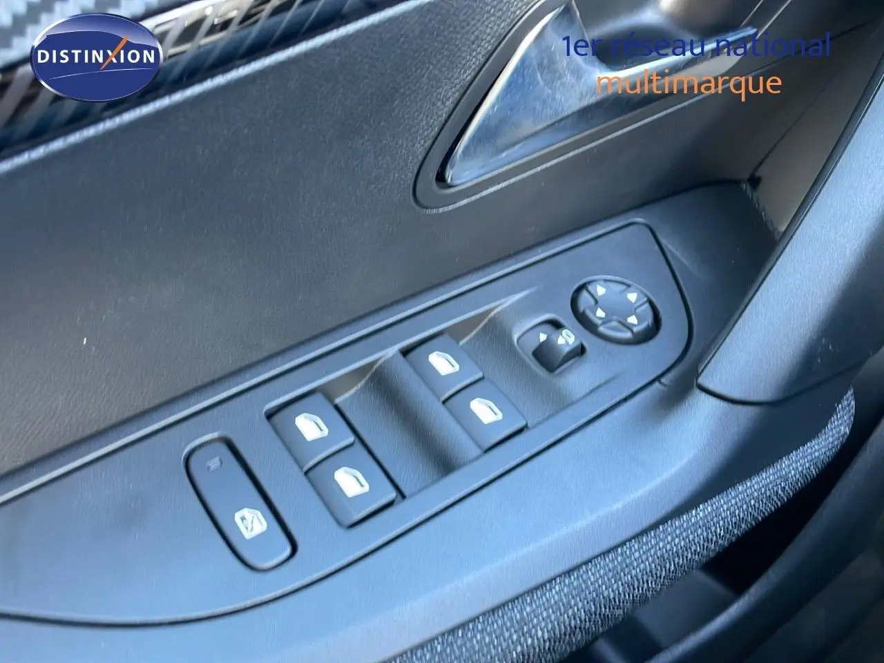 Commande des vitres électriques et réglage des rétroviseurs sur la porte côté conducteur d'un Peugeot 2008 blanc Okenite.