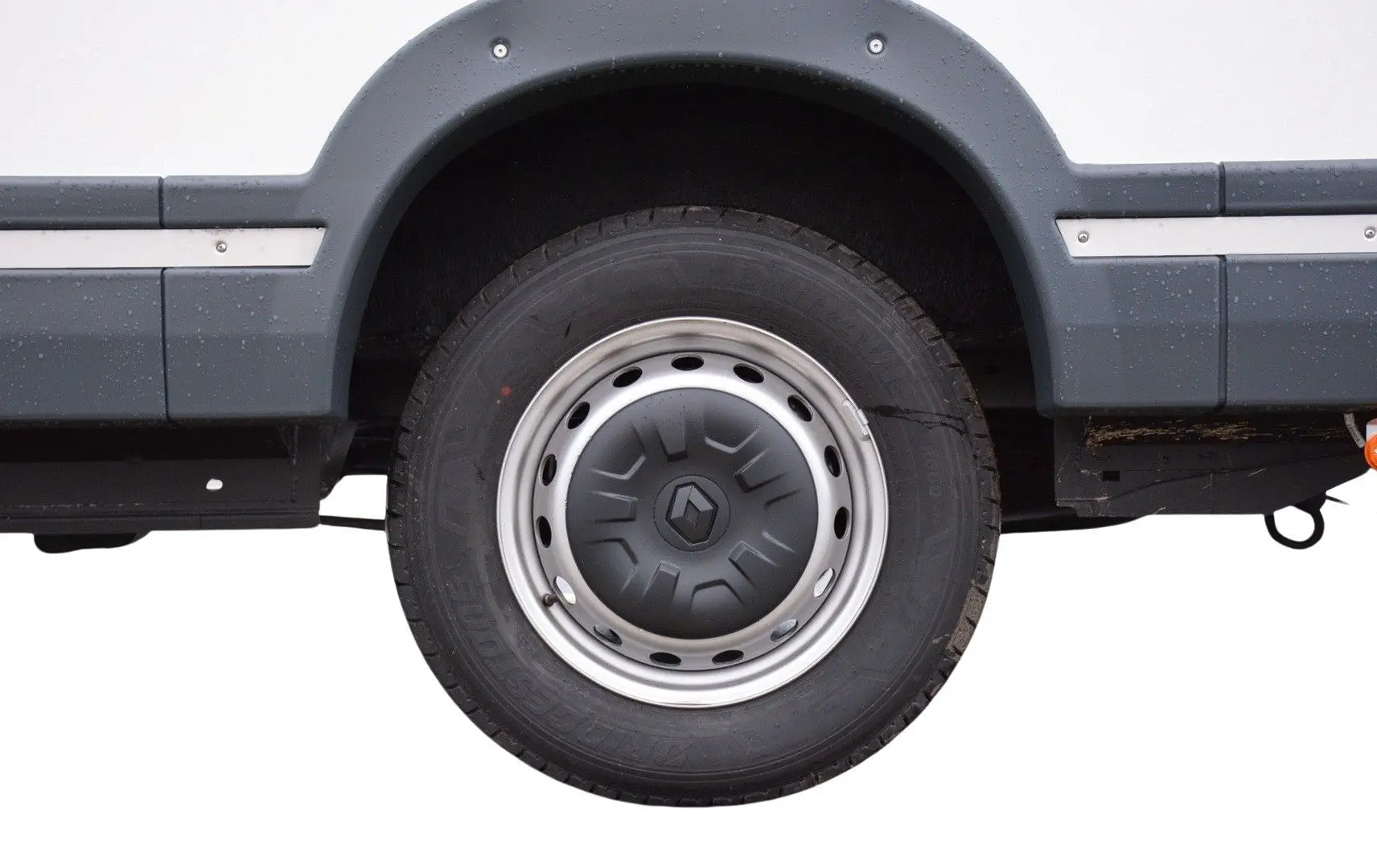 Gros plan sur la roue arrière droite blanche d’un Renault Master Plancher Cabine 2024 avec jante acier et enjoliveur gris.