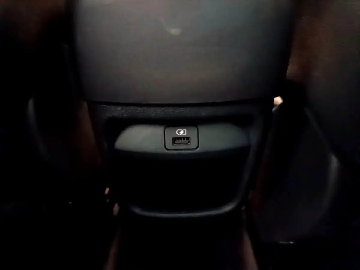 Prise USB arrière noire sur la console centrale du Nissan Juke Hybrid 143 Business+ 2022.