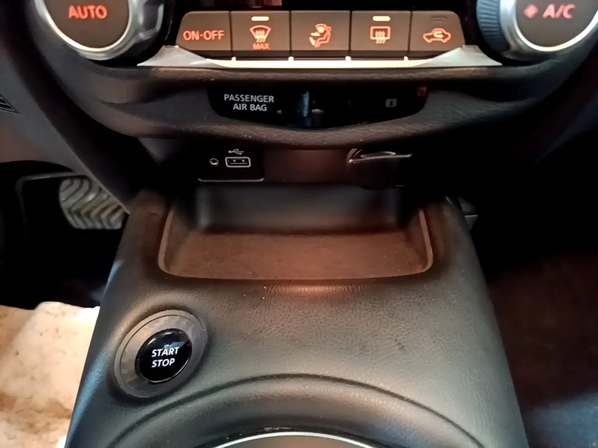 Vue rapprochée du bouton Start Stop noir sur la console centrale en cuir noir du Nissan Juke Hybrid 2022.