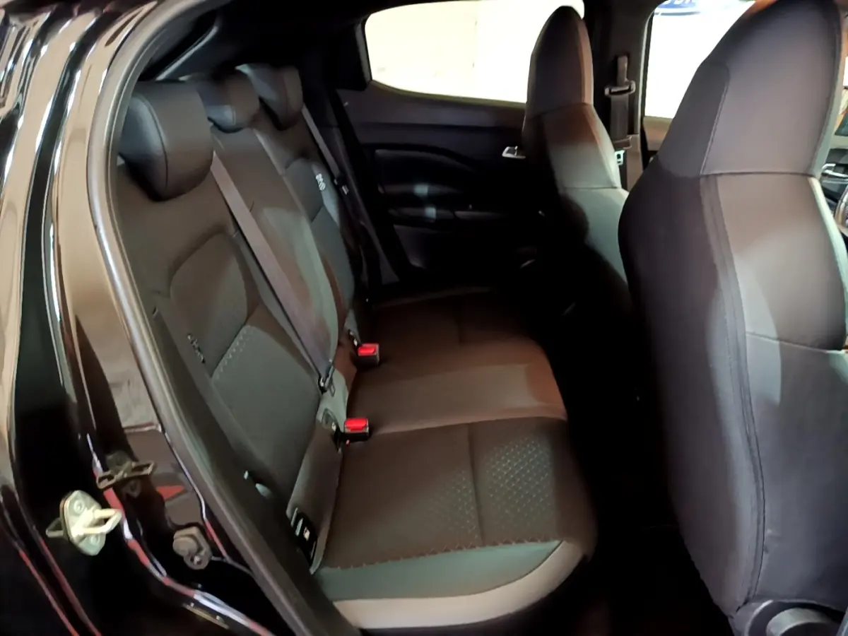 Vue intérieure côté gauche montrant la banquette arrière noire du Nissan Juke Hybrid 143 Business+ 2022.