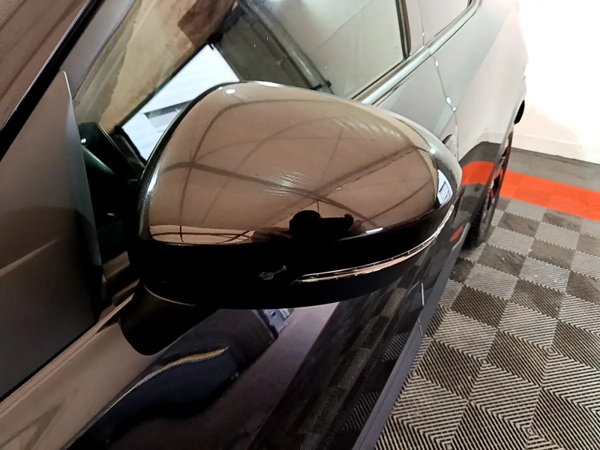 Rétroviseur côté gauche noir brillant du Nissan Juke Hybrid 143 Business+ 2022, vue rapprochée en angle oblique.