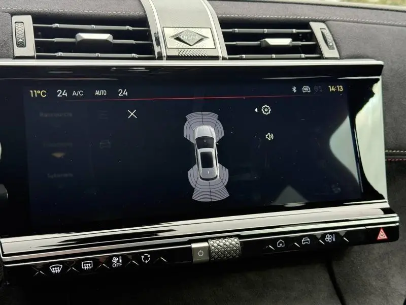 Écran tactile central du DS7 E-TENSE 225ch 2024 montrant l'aide au stationnement avec tableau de bord noir et finitions chromées.