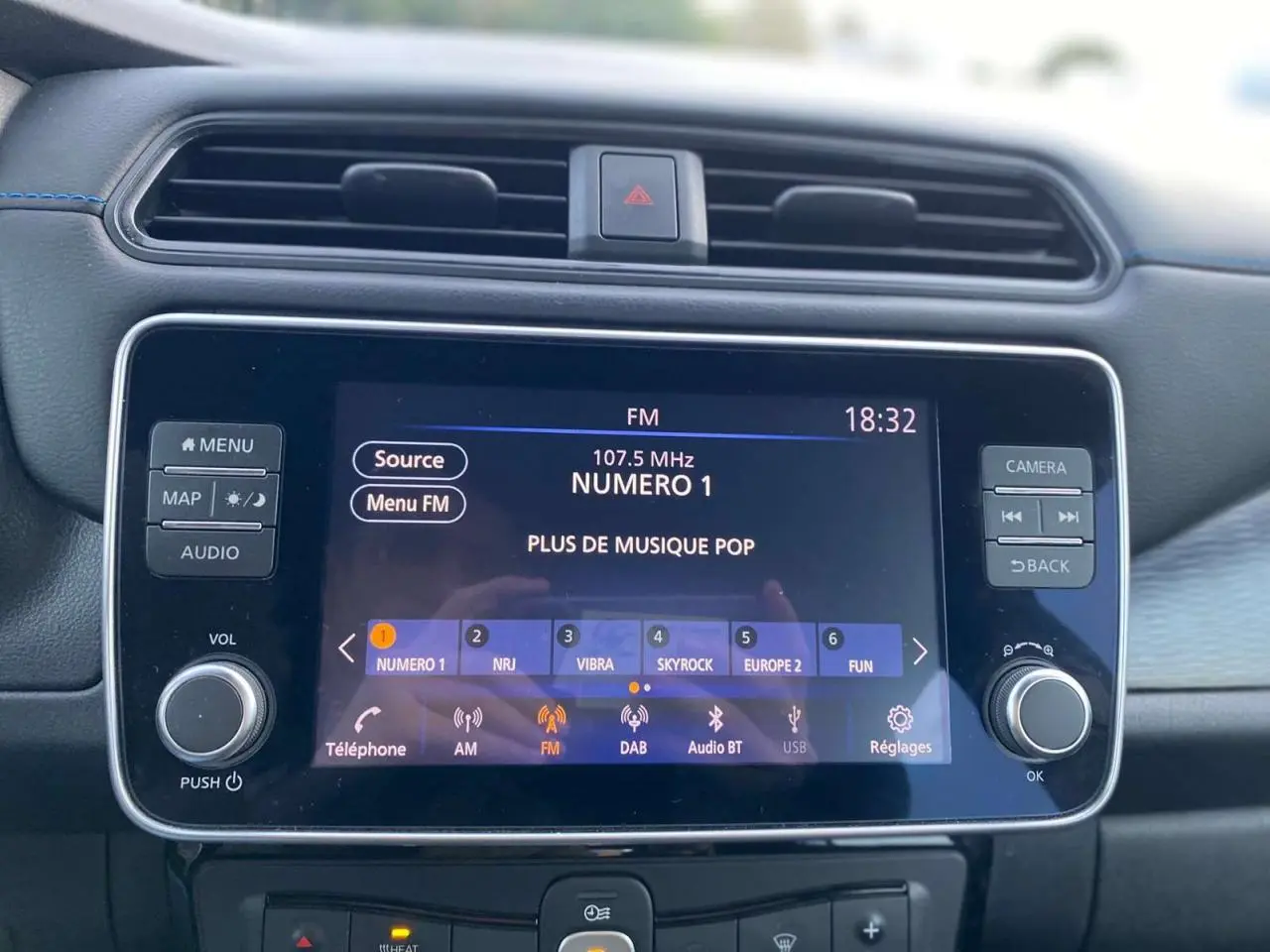 Écran tactile 8 pouces du tableau de bord de la Nissan Leaf 40 N-Connecta blanc, affichant la radio FM à 18h32.