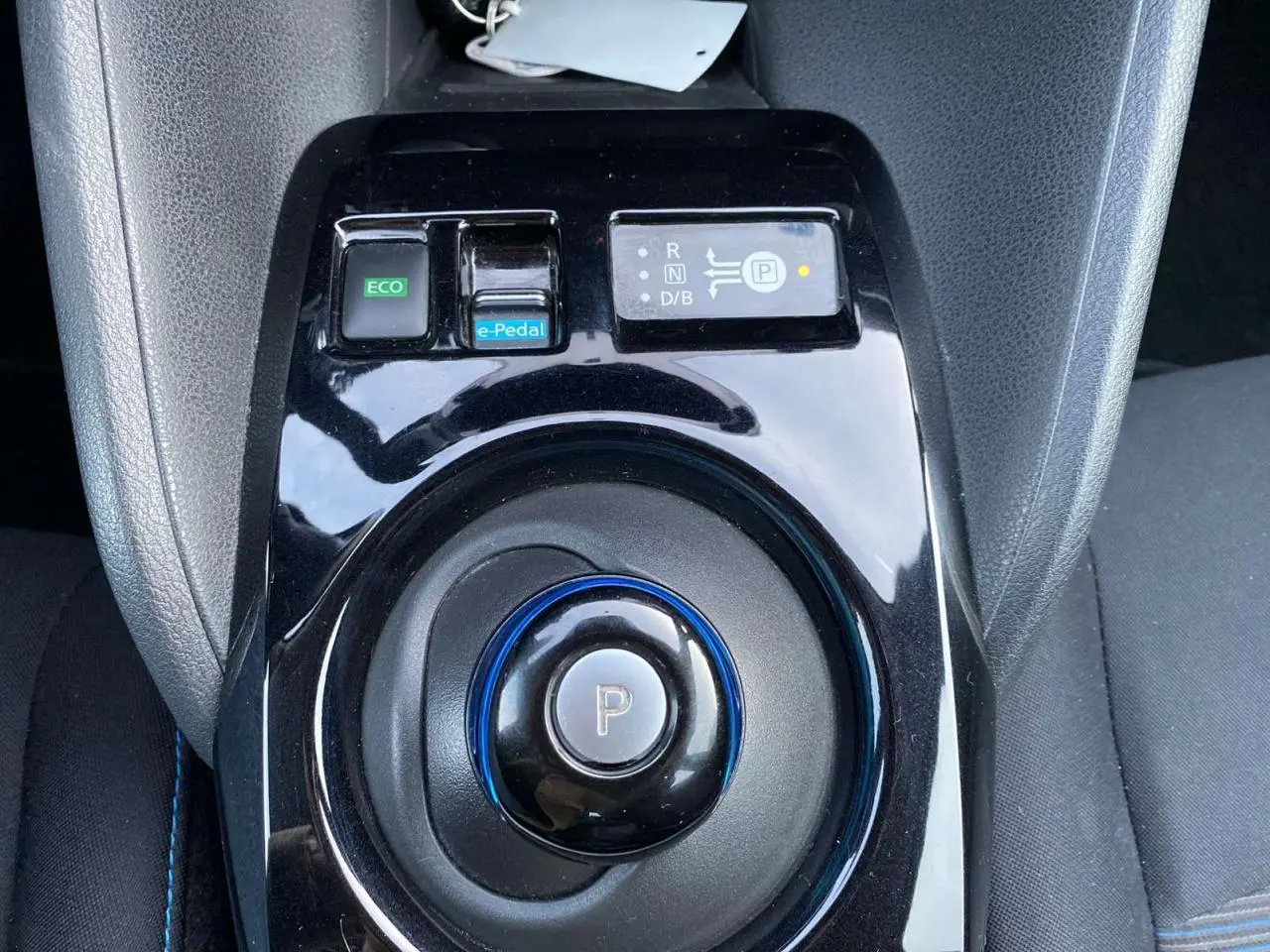 Vue rapprochée de la commande de boîte automatique noire avec bouton parking et touches e-Pedal et ECO d'une Nissan Leaf blanche 2020.