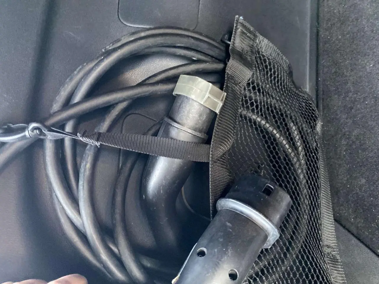 Câble de recharge électrique noir enroulé dans le coffre d'une Nissan Leaf blanche, version 40 N-Connecta.