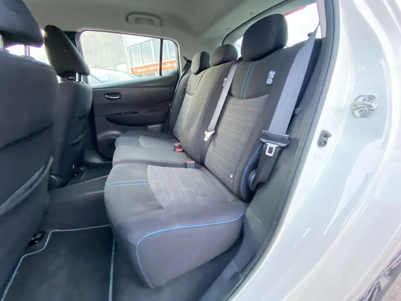 Vue intérieure côté droit des sièges arrière noirs avec surpiqûres bleues d'une Nissan Leaf 40 N-Connecta blanche de 2020.