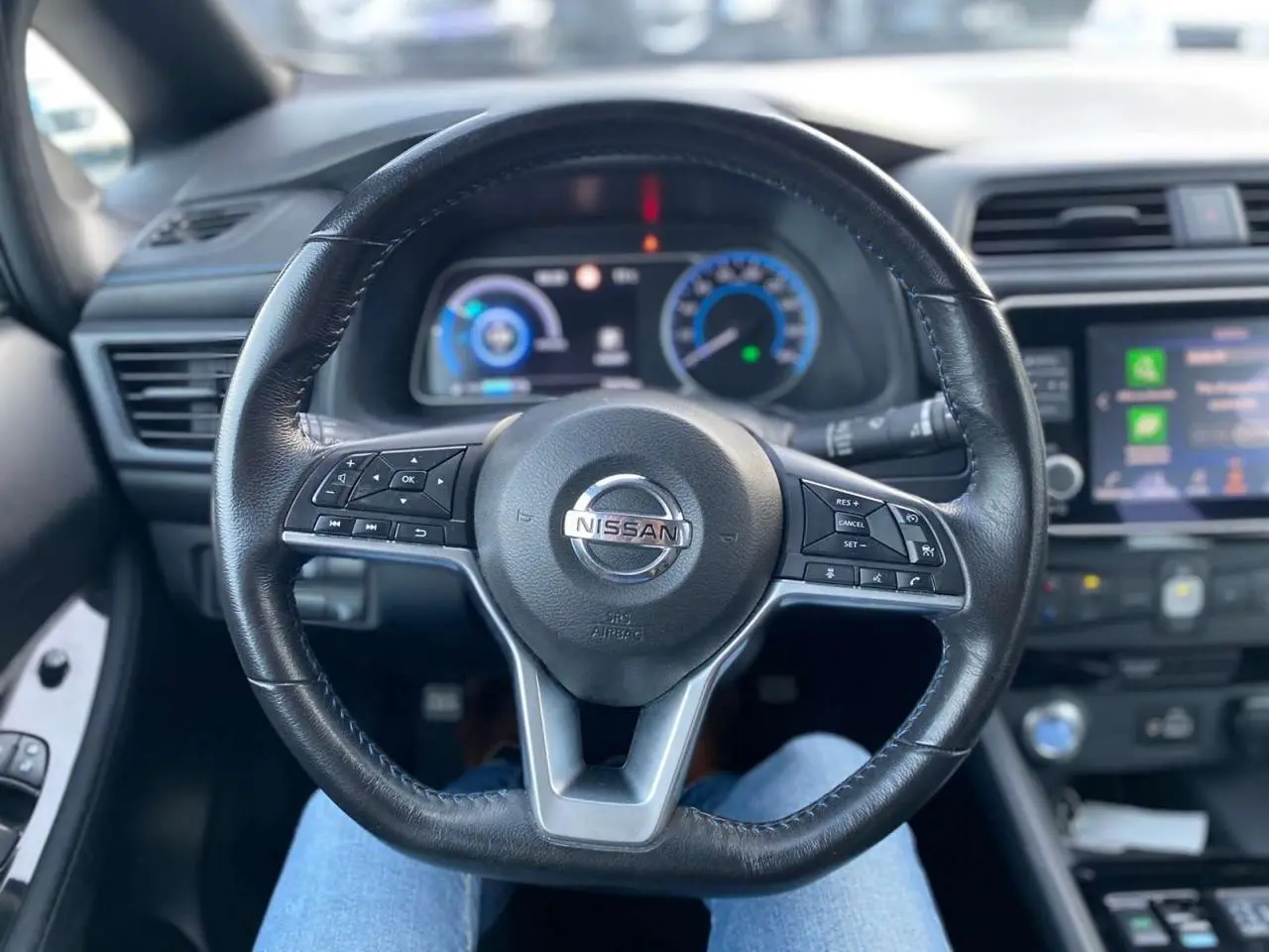 Vue intérieure centrée sur le volant noir du Nissan Leaf 40 N-Connecta 2020 avec tableau de bord et écran tactile visibles.