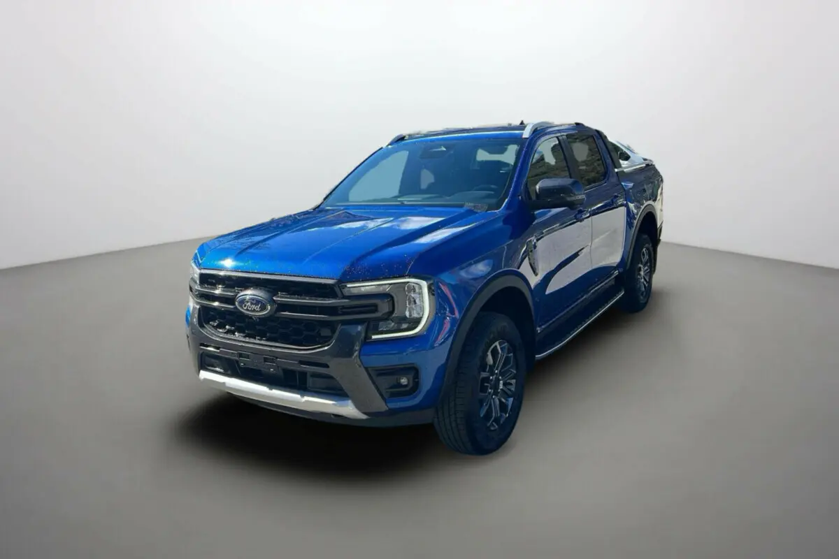 Ford Ranger 2.0 205 Wildtrak Plus bleu lightning vu en 3/4 avant droit avec barres de toit et jantes alu 20 pouces.