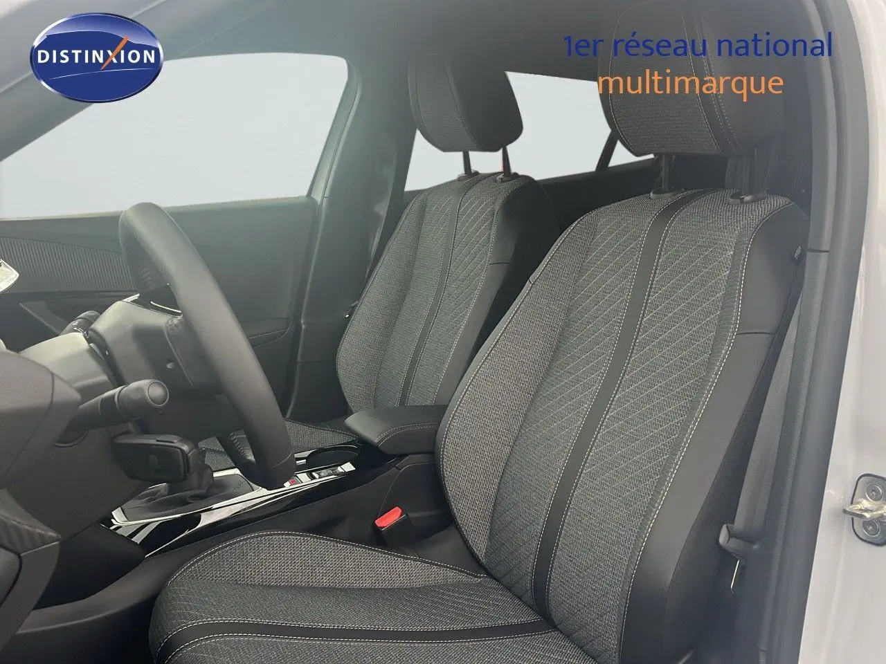 Intérieur de la Peugeot 2008 2025 en blanc, vue côté conducteur sur les sièges tissu noir et gris avec coutures contrastées.