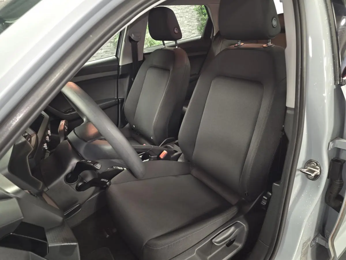 Intérieur de l'Audi A1 Sportback gris, vue côté conducteur sur les sièges avant en tissu noir.