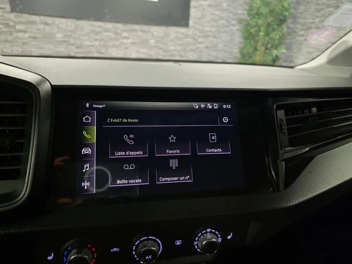 Écran tactile central de l'Audi A1 Sportback 2020 affichant le menu appels, entouré de la console noire et des commandes de climatisation.