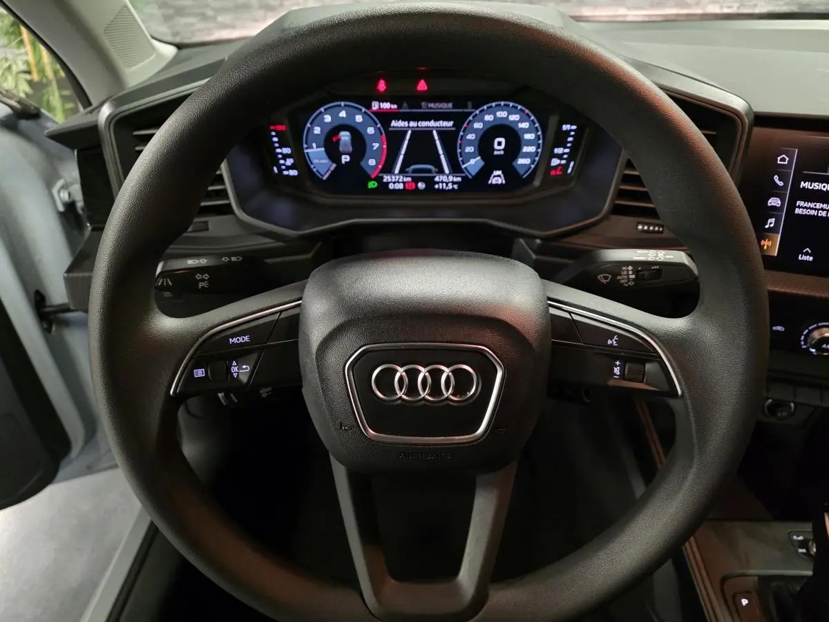 Vue rapprochée du volant noir multifonction et du tableau de bord numérique de l'Audi A1 Sportback 2020.