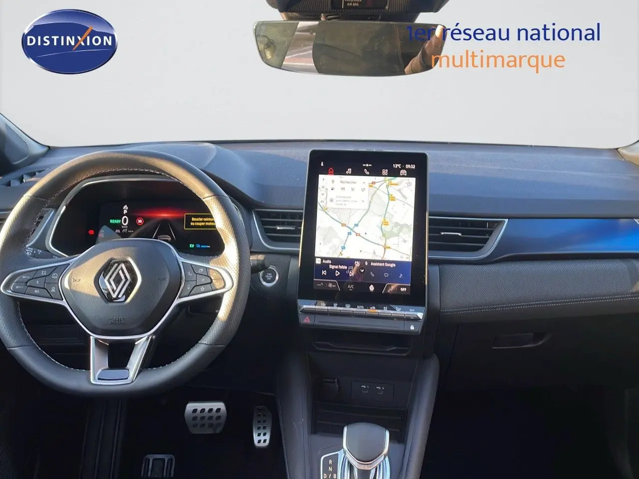 Vue intérieure du tableau de bord du Renault Captur E-Tech hybride 2025 avec écran tactile central et volant multifonction noir.