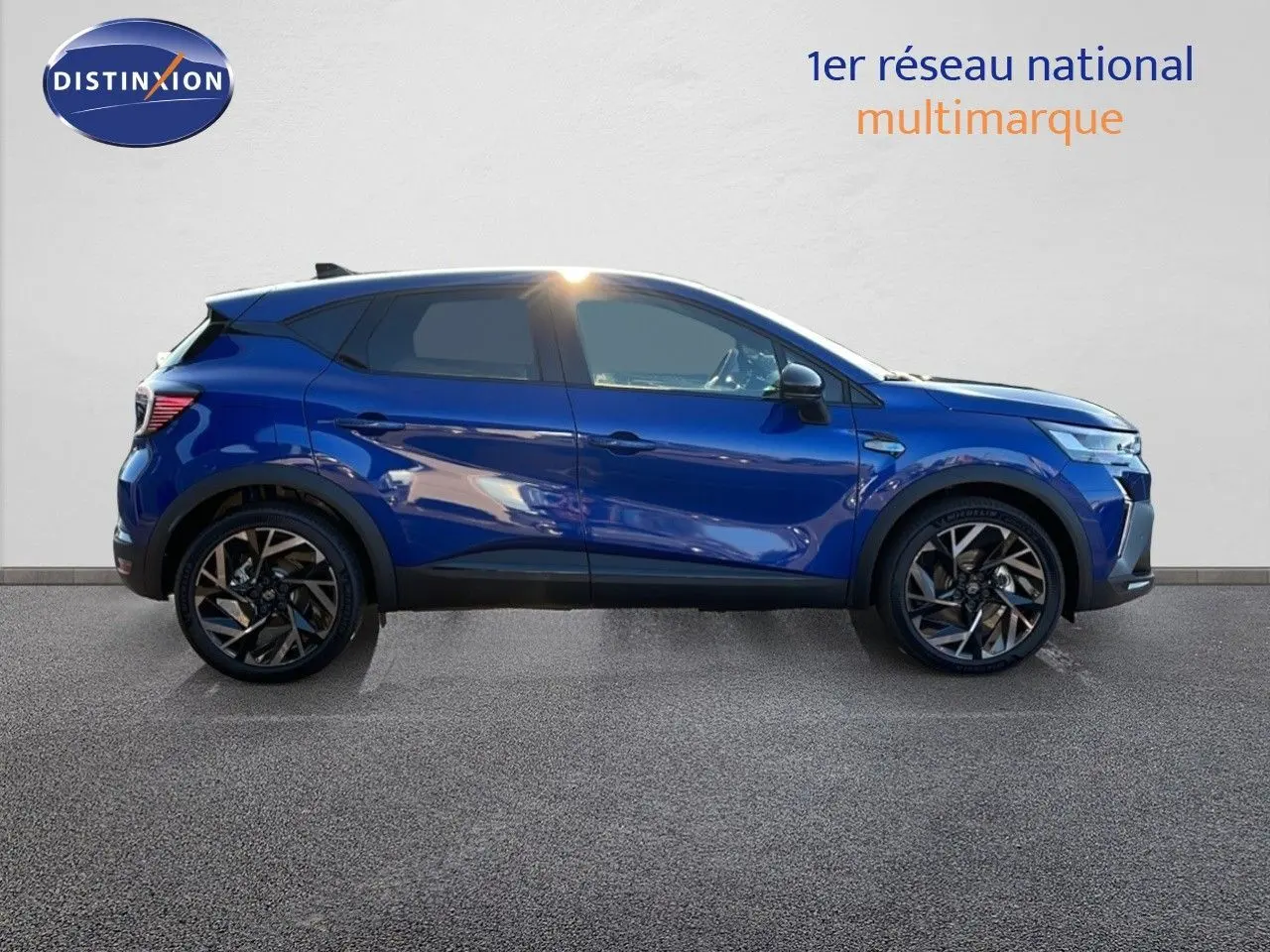 Profil côté gauche du Renault Captur E-Tech hybride 2025 en bleu Iron Metal avec toit noir et jantes noires.