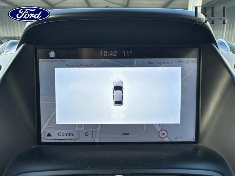 Écran central du Ford Kuga 2017 montrant la vue de dessus du véhicule gris lunaire avec navigation GPS active.