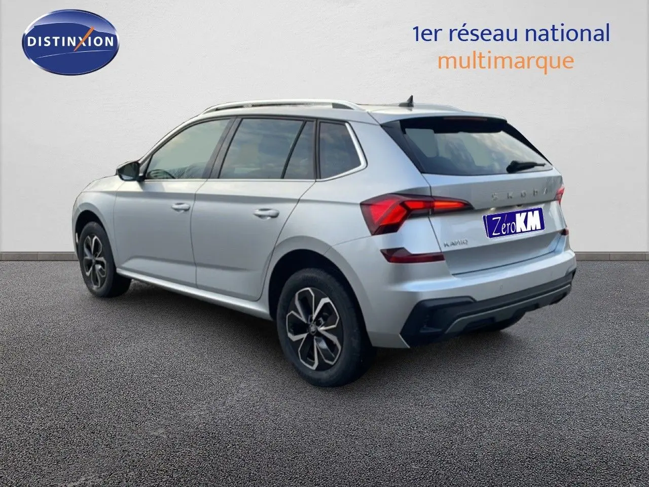 Vue 3/4 arrière côté droit d'un Skoda Kamiq gris argent métallisé avec jantes alliage et feux LED distinctifs.