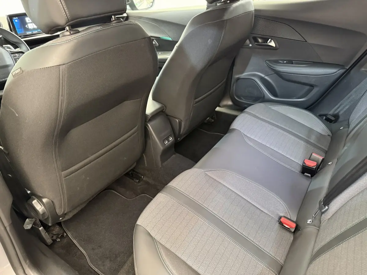 Vue arrière intérieure du Peugeot 2008 gris clair, sièges arrière en tissu et cuir avec ports USB visibles.
