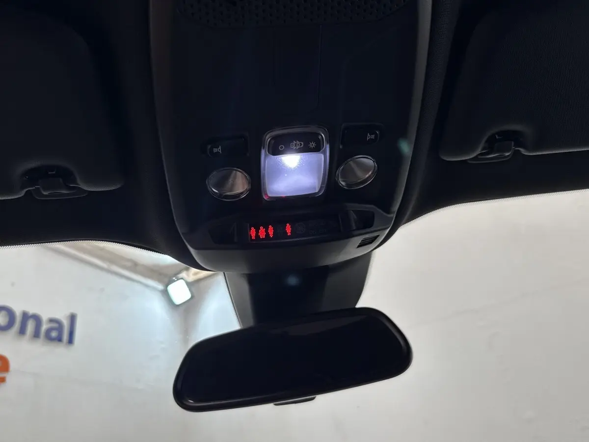 Vue intérieure en plongée sur le plafonnier et le rétroviseur d'une Peugeot 2008 gris clair, avec éclairage LED allumé.