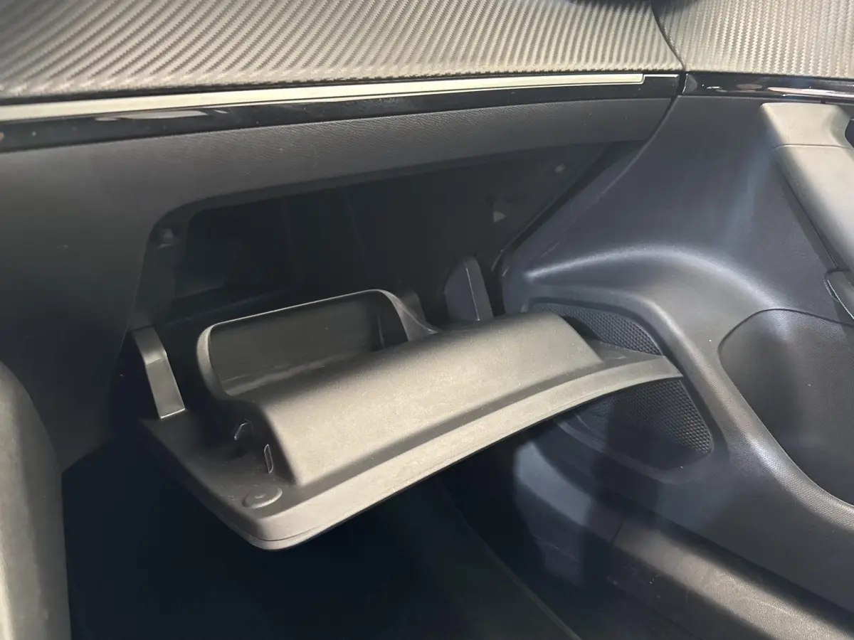 Gros plan sur la boîte à gants ouverte côté passager du Peugeot 2008 gris clair, intérieur noir moderne.