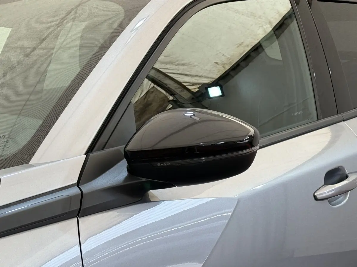 Vue rapprochée du rétroviseur noir sur la porte côté conducteur d’un Peugeot 2008 gris clair 2023.