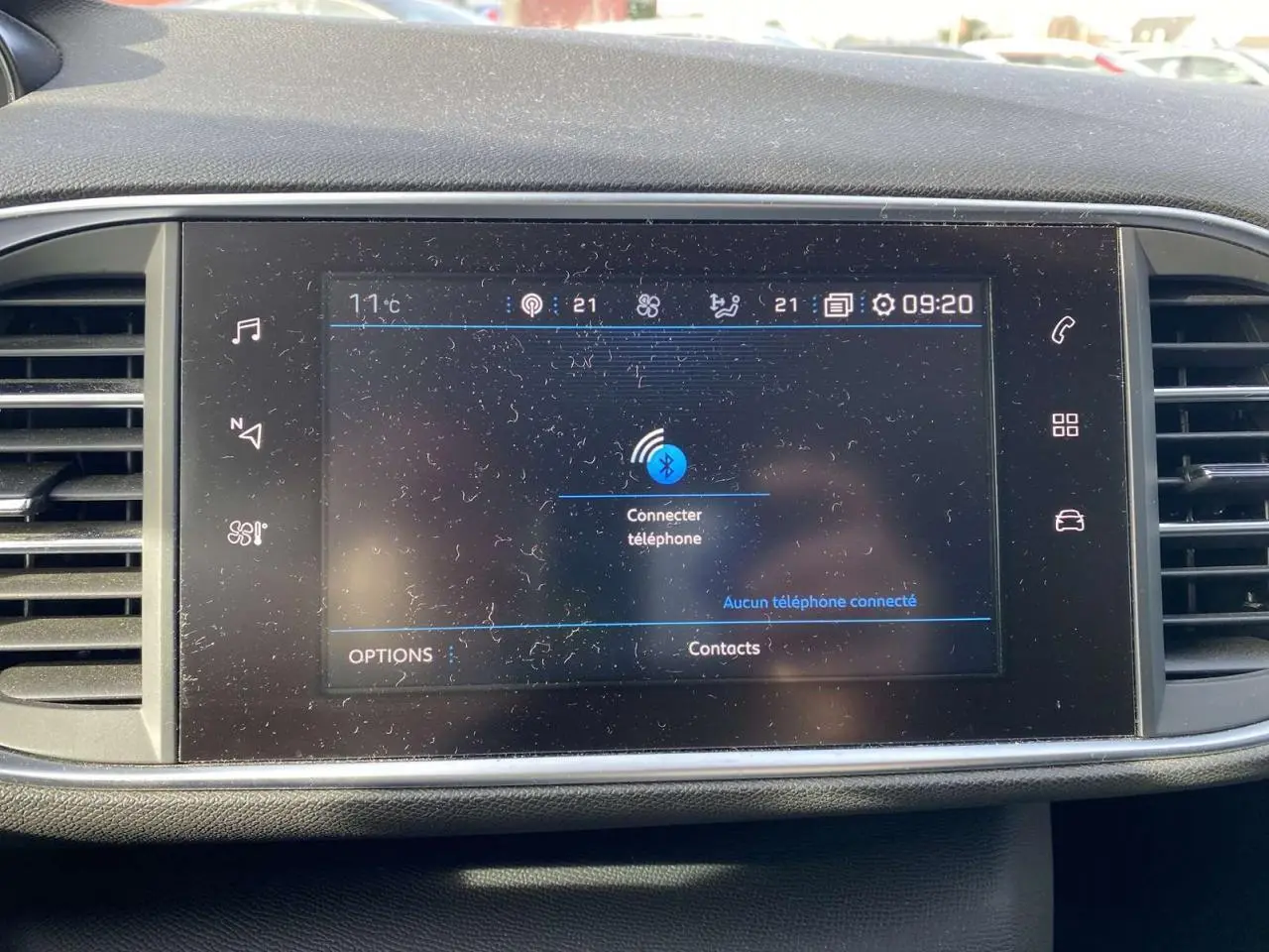 Écran tactile central de la Peugeot 308 blanc nacré 2017 affichant la connexion Bluetooth au téléphone.