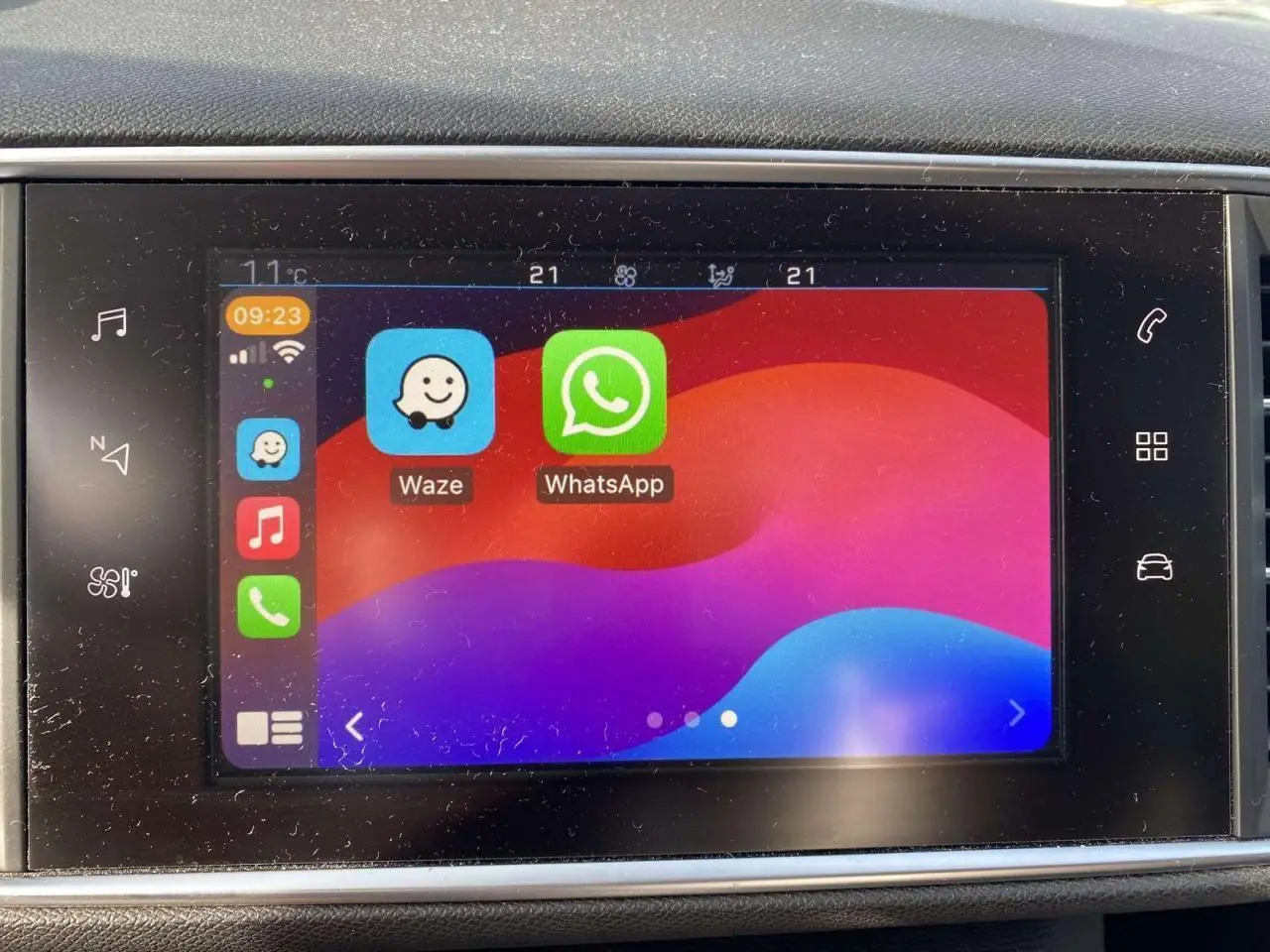 Écran tactile 9,7'' de la Peugeot 308 blanc nacré montrant les applications Waze et WhatsApp en interface connectée.