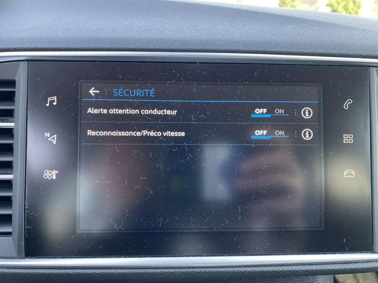 Écran tactile central de la Peugeot 308 blanc nacré montrant les réglages de sécurité du conducteur.