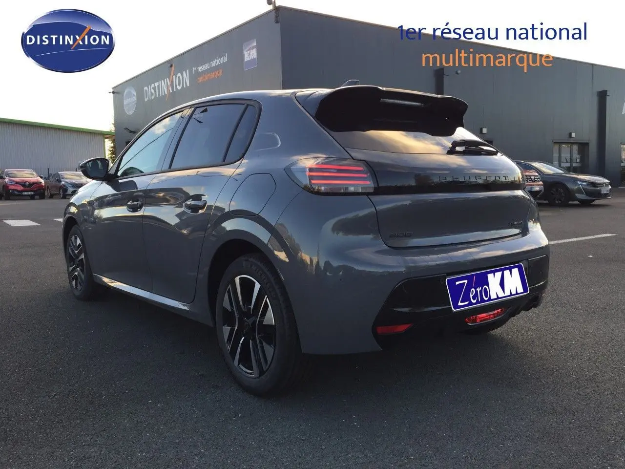 Vue 3/4 arrière droite d'une Peugeot 208 hybride gris sélénium métal avec feux arrière LED et jantes noires.