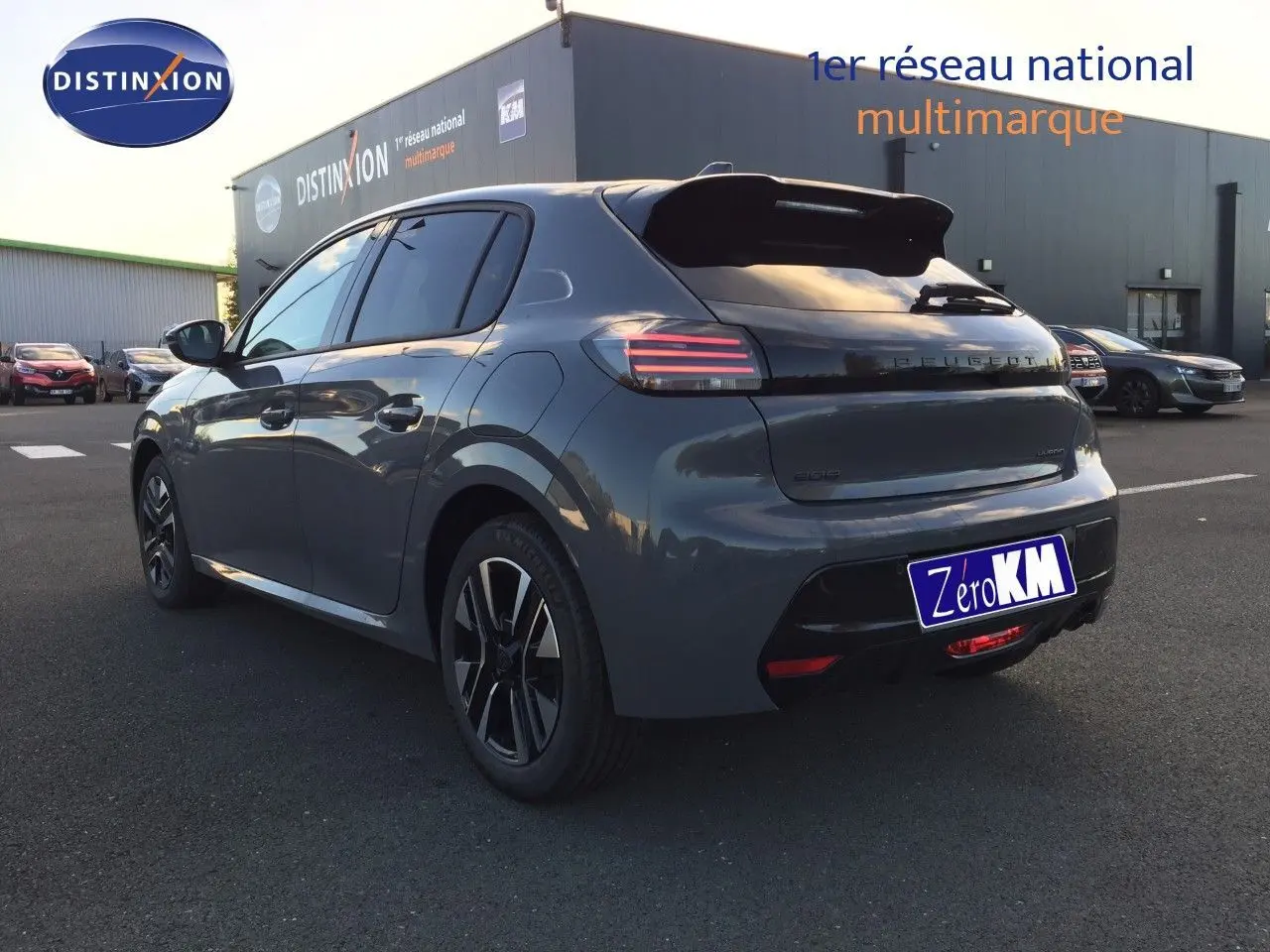 Vue 3/4 arrière gauche d'une Peugeot 208 hybride 2025 gris selenium metal avec feux arrière LED et jantes alliage.