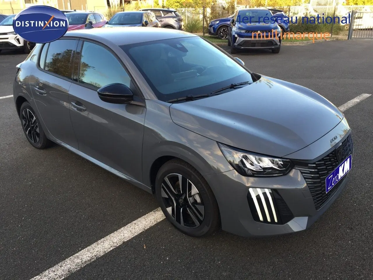 PEUGEOT 208 gris selenium métal vue 3/4 avant droit avec feux LED et jantes noires distinctives.