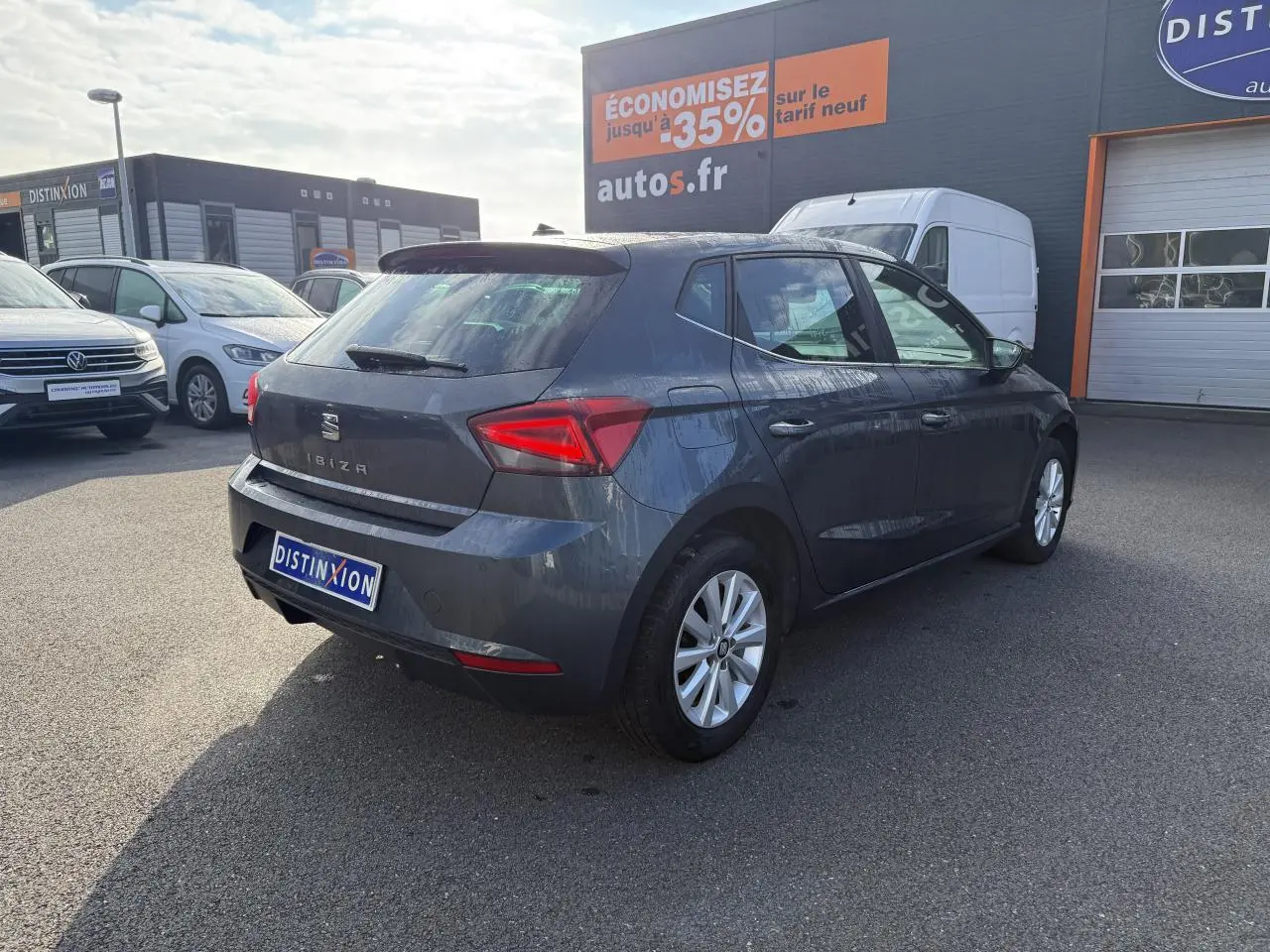 SEAT Ibiza 1.0 EcoTSI 95 Xcellence gris Magnetic Tech vue 3/4 arrière droit sur parking extérieur.