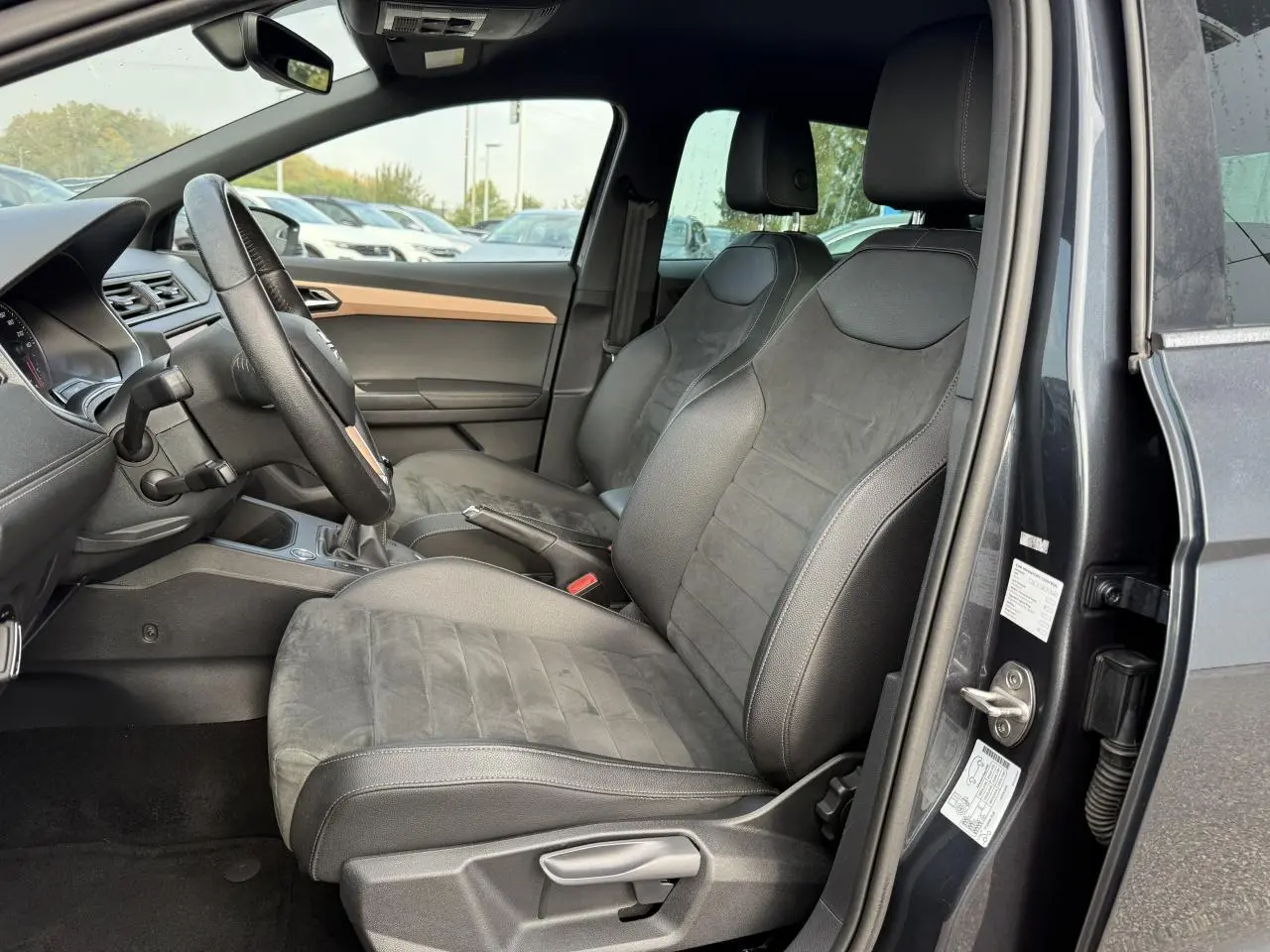 Intérieur côté conducteur de la SEAT IBIZA 2019 gris Magnetic Tech, sièges confort en tissu et alcantara, volant et tableau de bord visibles.