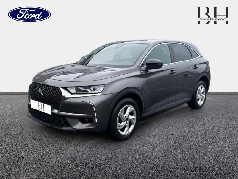 DS7 Crossback gris Platinium vu en 3/4 avant droit avec calandre noire et jantes argentées.