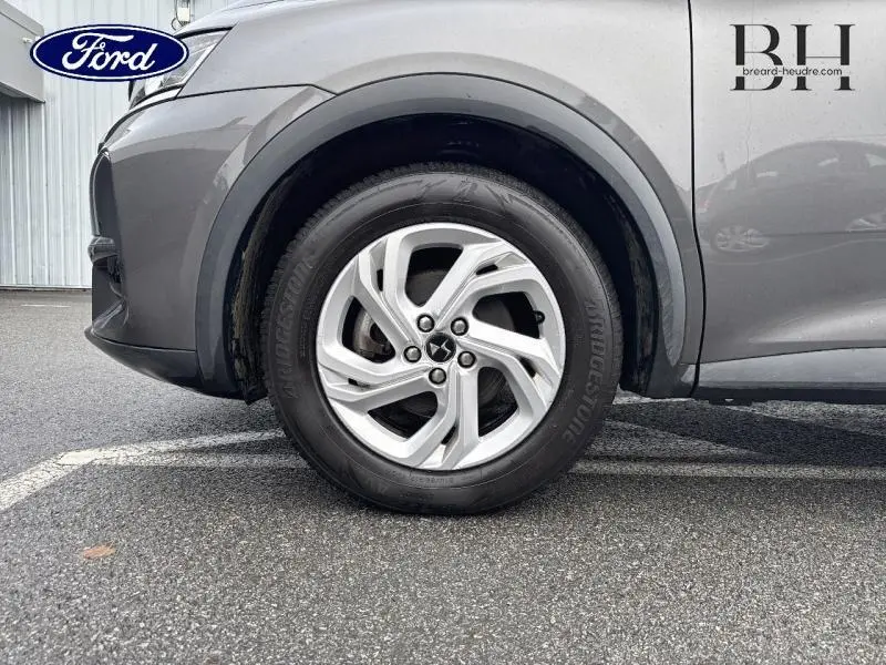 Gros plan sur la roue avant droite d'un DS7 Crossback gris Platinium avec jante alliage cinq branches.