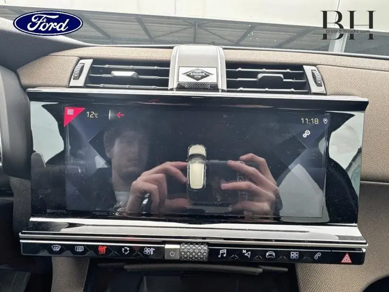 Écran tactile central du tableau de bord du DS7 Crossback gris Platinium, avec commandes clim et multimédia visibles.