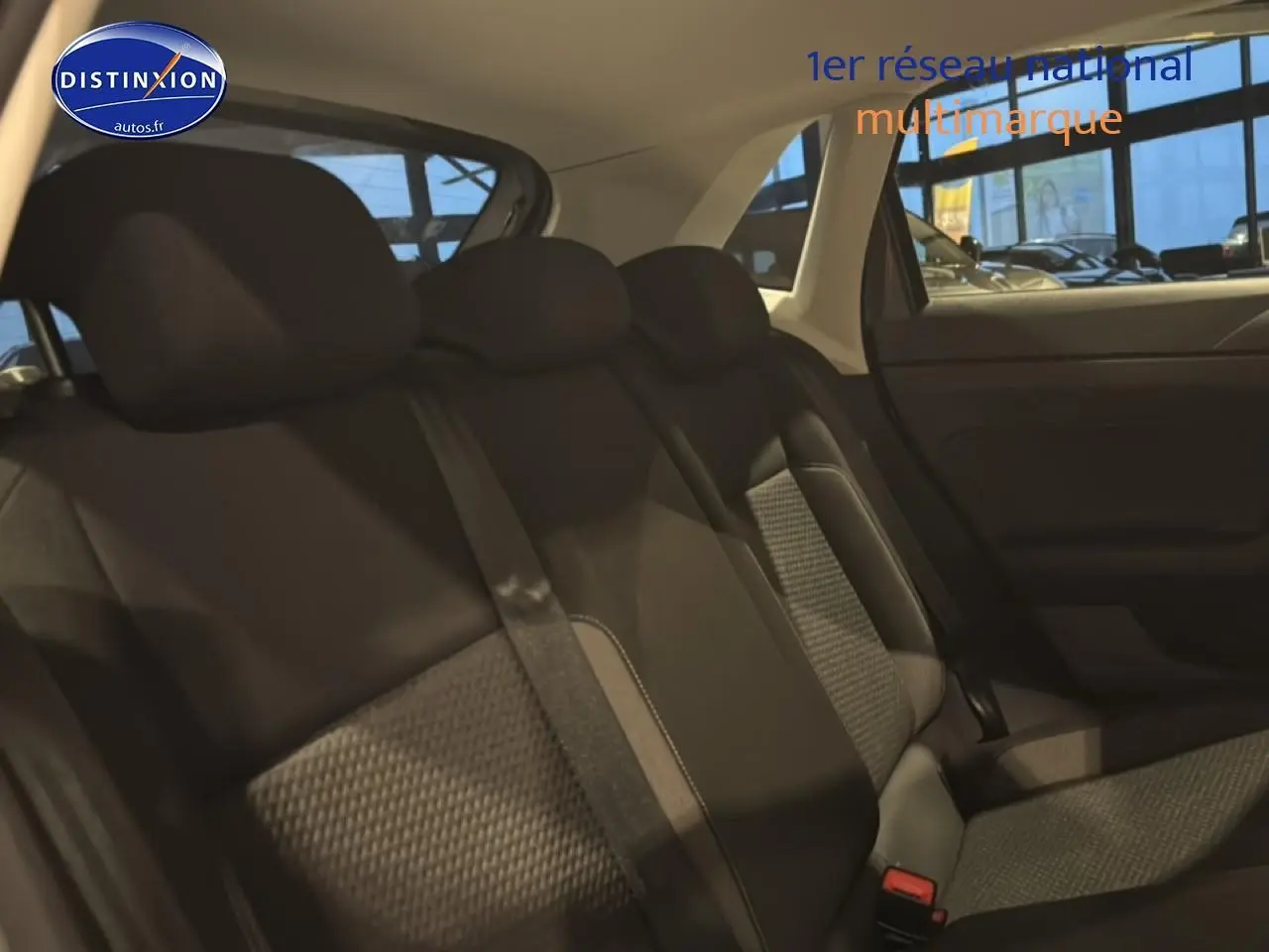 Vue intérieure côté droit montrant la banquette arrière en tissu noir avec motifs gris d'une Volkswagen Polo gris cendre.