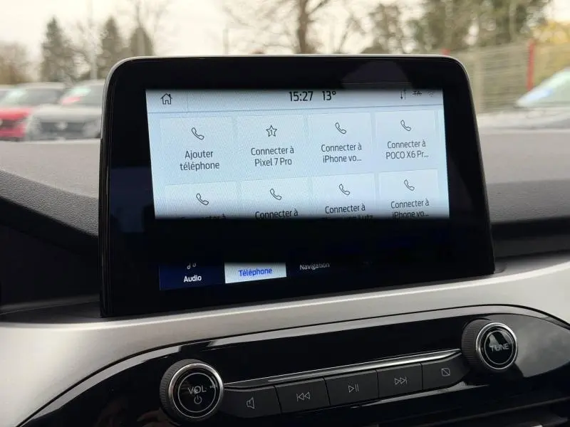 Écran tactile central du Ford Kuga 2024, vue frontale intérieure, avec commandes audio et connectivité téléphone visibles.