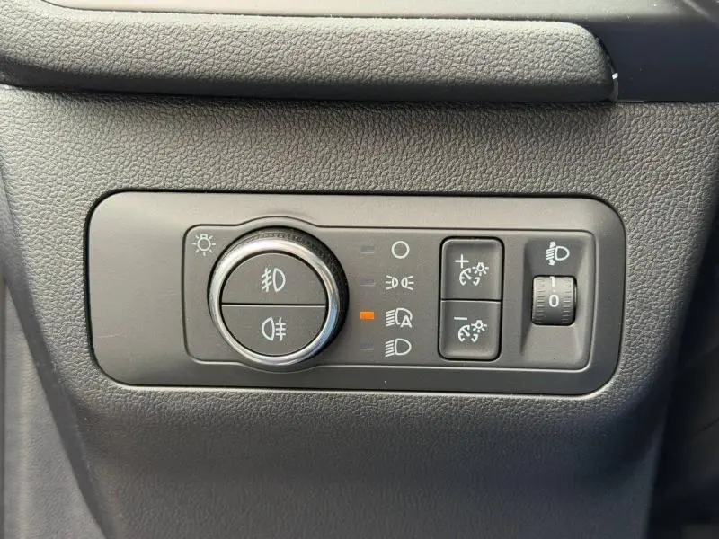 Gros plan sur le panneau de commande des phares du Ford Kuga 2024, finition Titanium, avec réglages éclairage et antibrouillard.