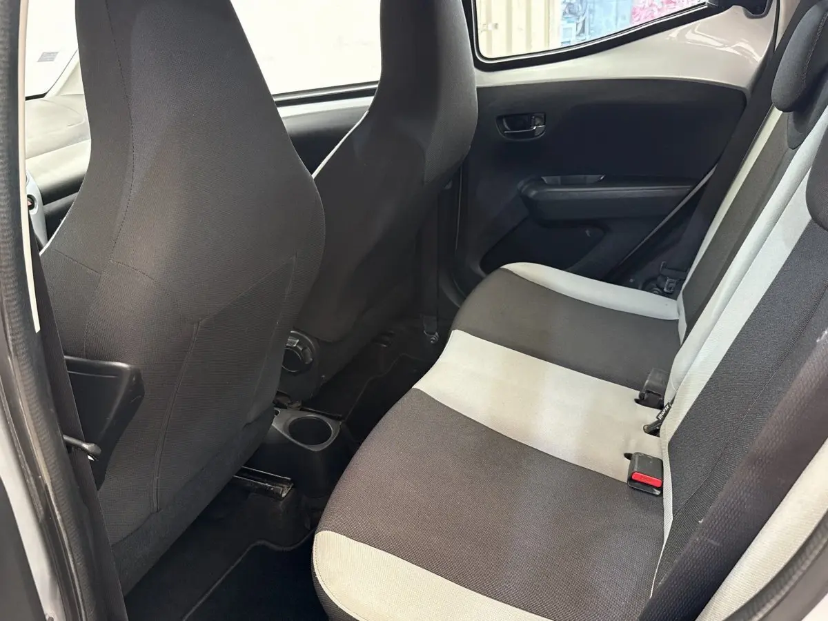 Vue intérieure montrant la banquette arrière bicolore gris clair et noir de la Toyota Aygo 2017, côté droit.